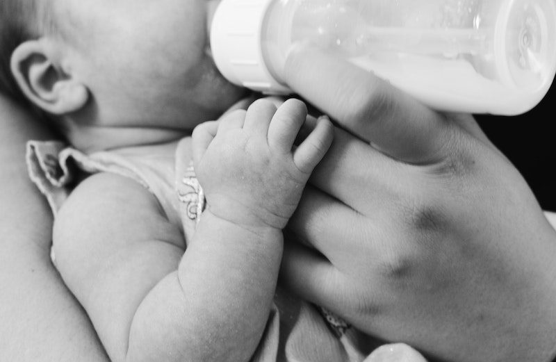 Closeup of baby with bottle in black and white