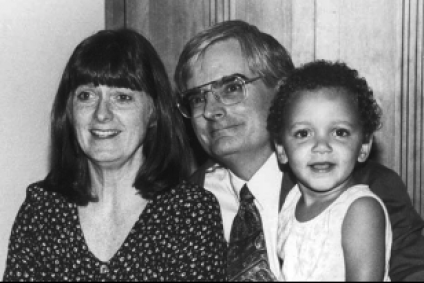 Three people in black and white: A woman, a man with glasses, and a child.