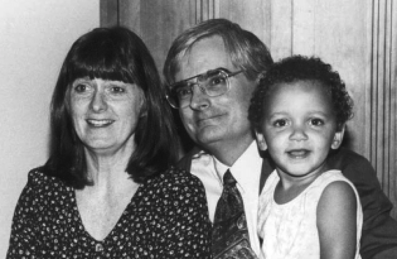 Three people in black and white: A woman, a man with glasses, and a child.