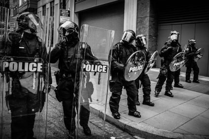 Black and white photo of six police officers in Washington DC in riot gear