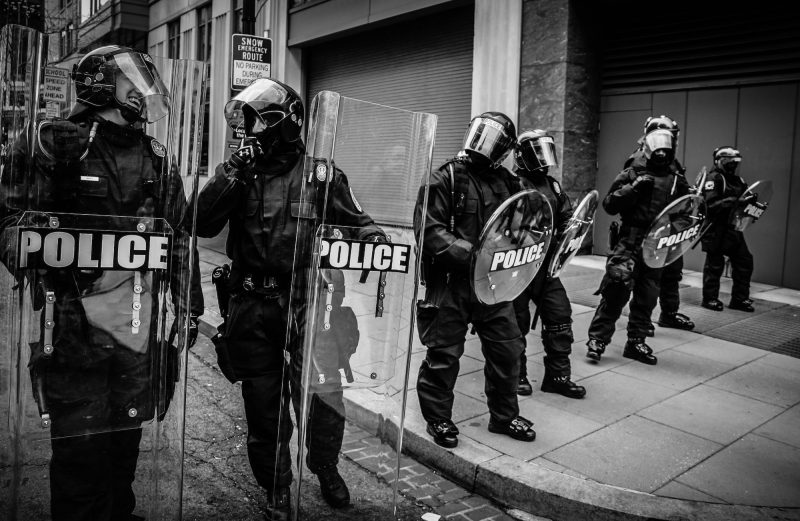 Black and white photo of six police officers in Washington DC in riot gear