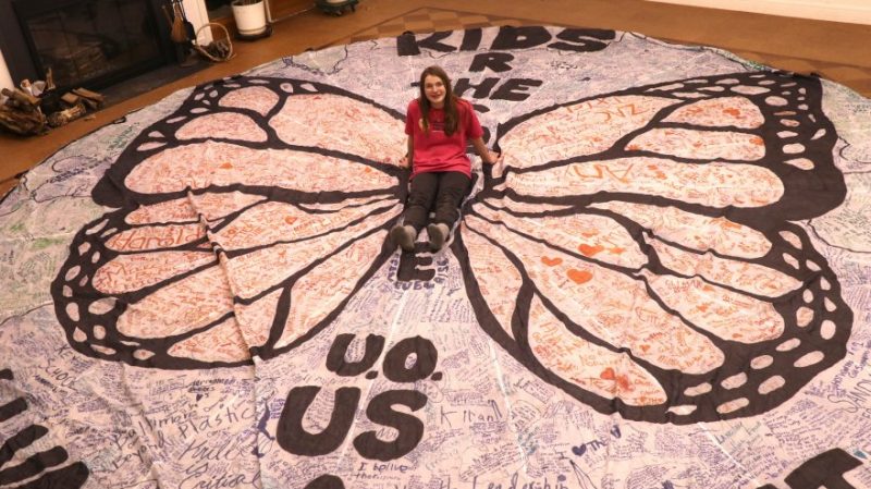 Kallan Benson sits on her butterfly parachute