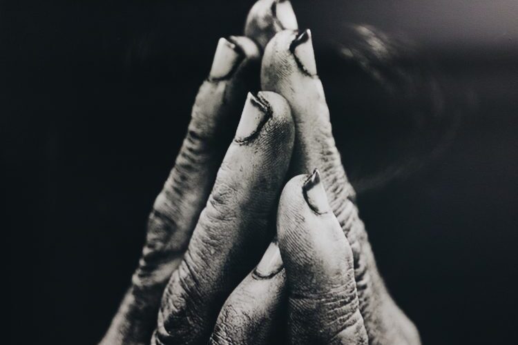 Black and white photo of two hands coming together