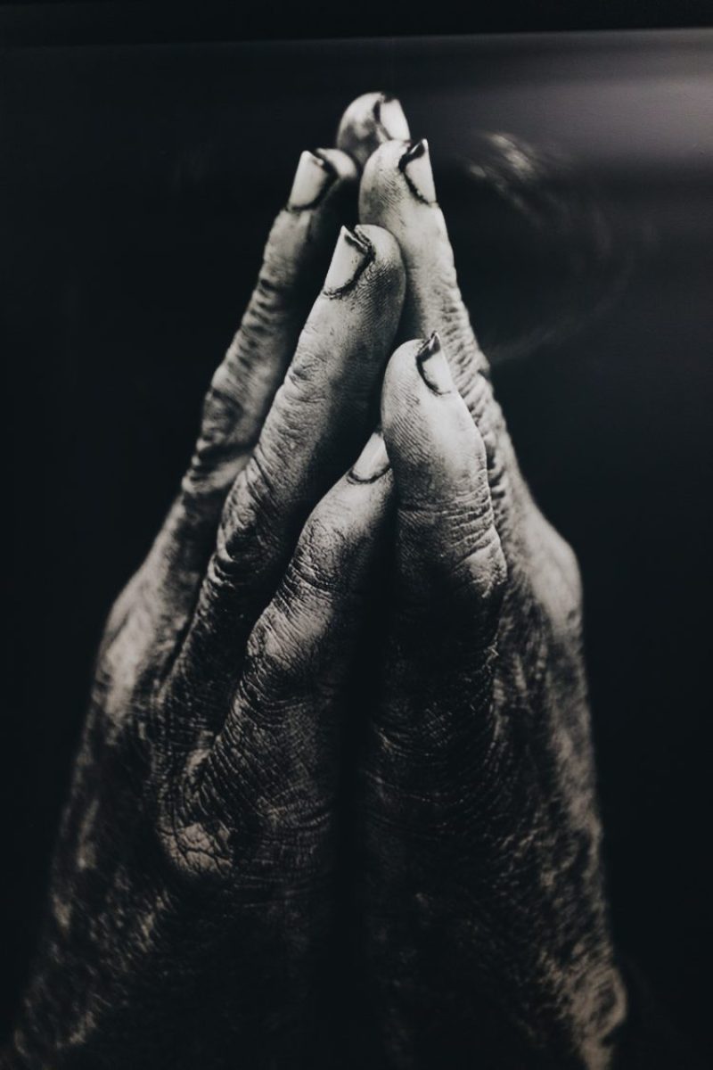 Black and white photo of two hands coming together