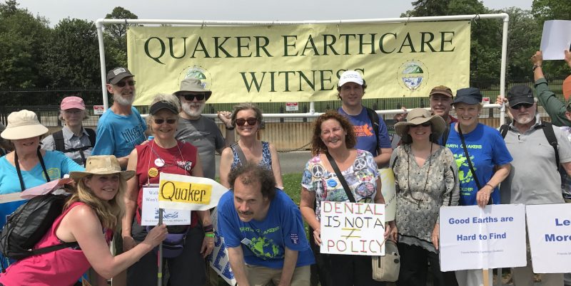 Smiling group of people in front of Quaker Earthcare Witness sign