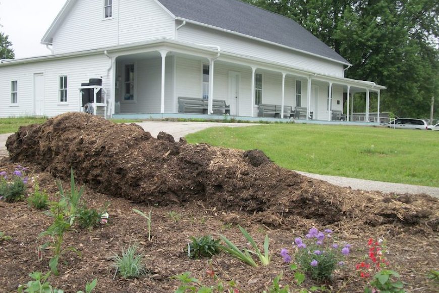 White meetinghouse with beginning garden in foreground