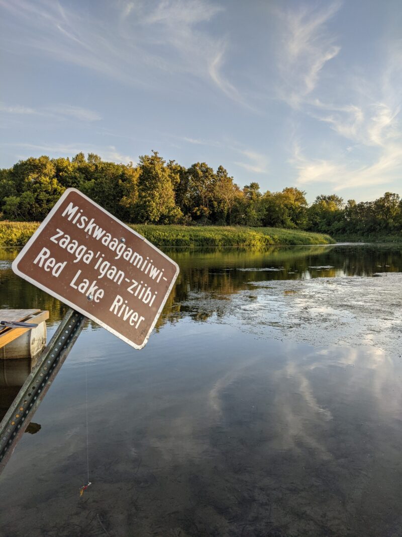 River with sign labeling Miskwaagamiiwizaaga'igan-ziibi Red Lake River