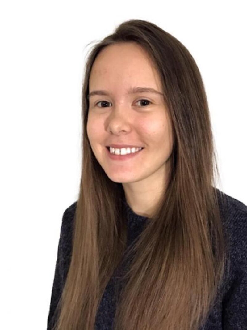 Person with long brown hair smiling and white background