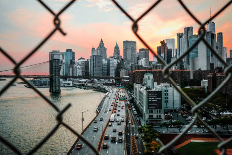 Cityscape as seen through a broken, rusty fence